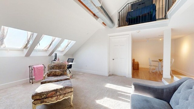 52 Sanborn St Unit 408, Reading, MA 01867 - living area featuring baseboards, vaulted ceiling with skylight, and carpet
