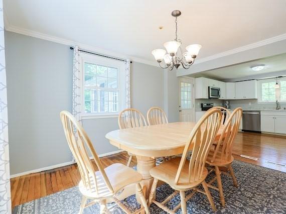 230 2nd St, Stoughton, MA 02072 - dining area with ornamental molding, a chandelier, wood finished floors, and baseboards