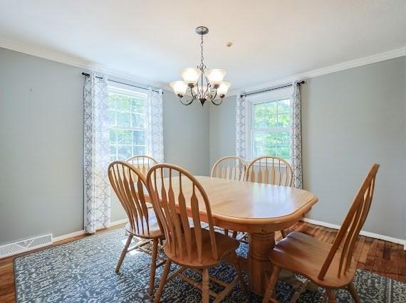 230 2nd St, Stoughton, MA 02072 - dining area featuring a chandelier, plenty of natural light, wood finished floors, baseboards, and crown molding