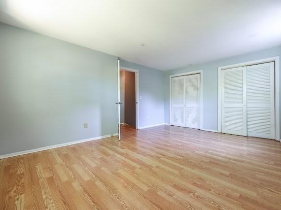 230 2nd St, Stoughton, MA 02072 - unfurnished bedroom with two closets, light wood-type flooring, and baseboards
