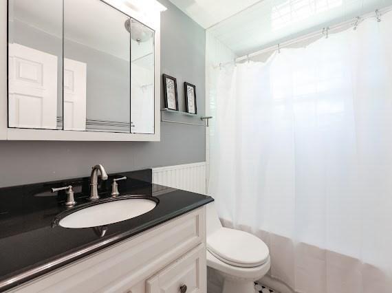 230 2nd St, Stoughton, MA 02072 - full bath featuring vanity, toilet, shower / bathtub combination with curtain, and a wainscoted wall