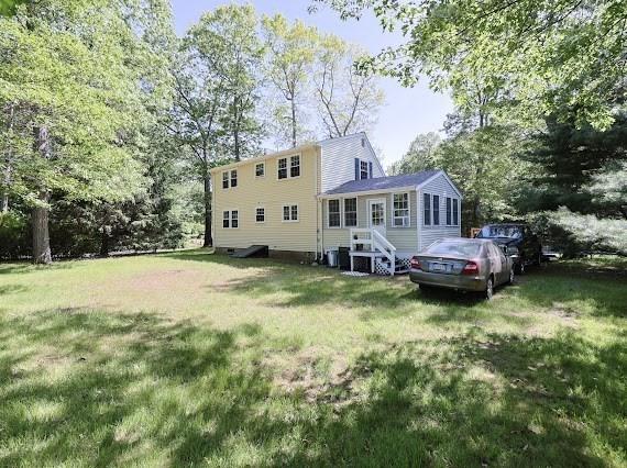 230 2nd St, Stoughton, MA 02072 - back of house with a lawn, cooling unit, and view of wooded area