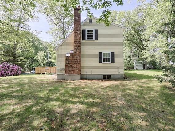 230 2nd St, Stoughton, MA 02072 - rear view of property with a lawn and a chimney