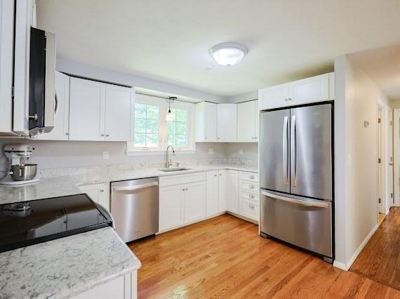 230 2nd St, Stoughton, MA 02072 - kitchen with appliances with stainless steel finishes, a sink, light wood-style flooring, and white cabinetry