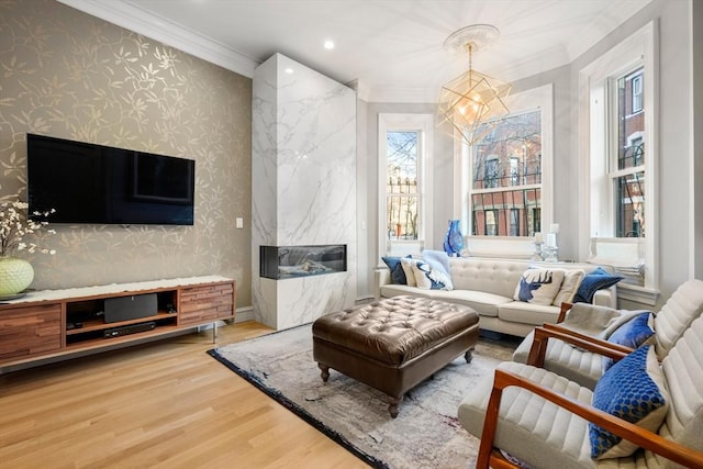 interior space with ornamental molding, a chandelier, hardwood / wood-style floors, and a fireplace