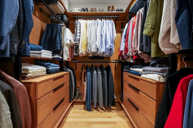 walk in closet with light hardwood / wood-style floors