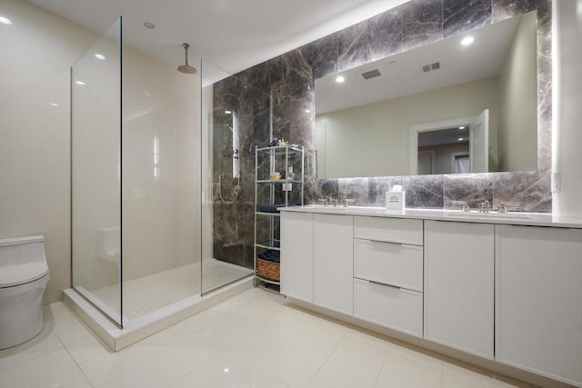 bathroom featuring tile patterned flooring, vanity, tile walls, toilet, and tiled shower