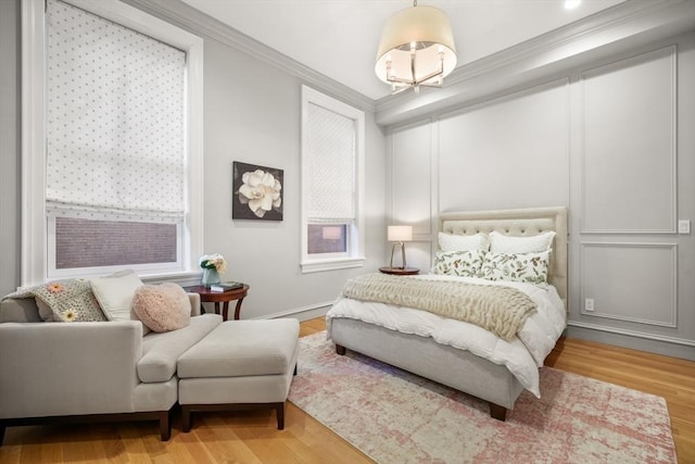 bedroom with light hardwood / wood-style floors and crown molding