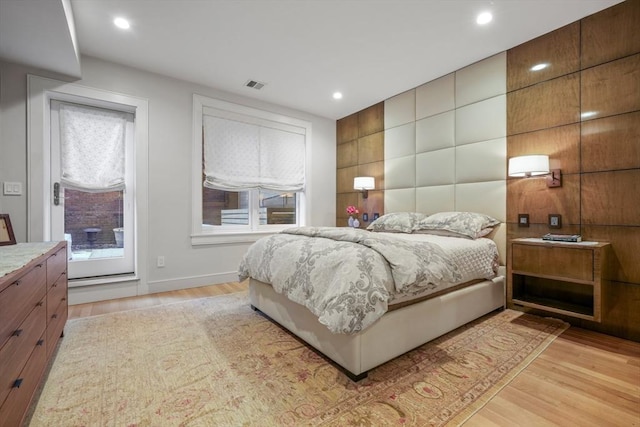 bedroom with multiple windows and light hardwood / wood-style flooring