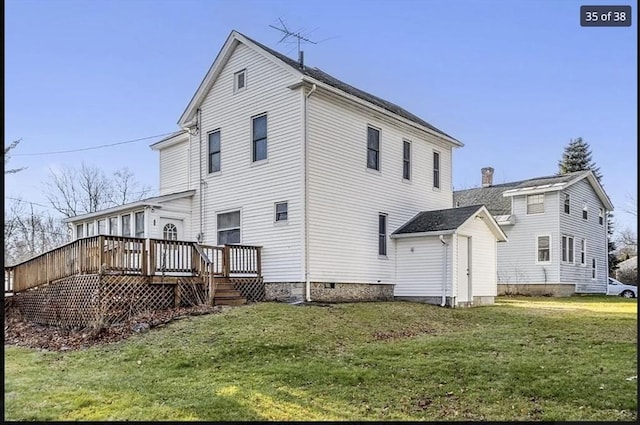 back of property with a wooden deck and a lawn