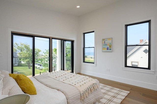 bedroom with wood-type flooring and access to outside