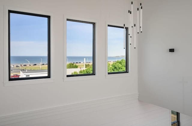 unfurnished room featuring a water view and light hardwood / wood-style floors
