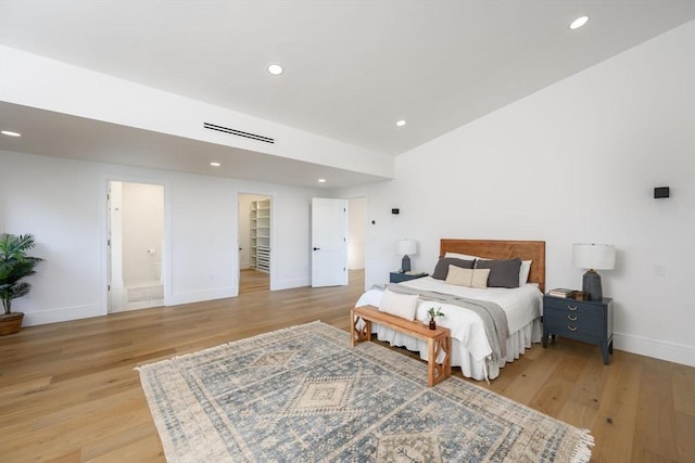 bedroom featuring light wood-type flooring and connected bathroom