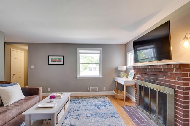 477 Laws Brook Rd, Concord, MA 01742 - living area with wood finished floors, baseboards, and a brick fireplace