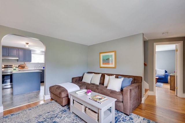 477 Laws Brook Rd, Concord, MA 01742 - living room with arched walkways, light wood-type flooring, and baseboards
