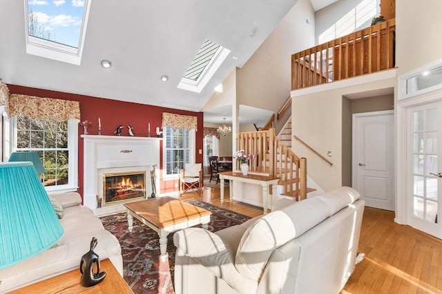 living area with stairs, a skylight, wood finished floors, and a wealth of natural light