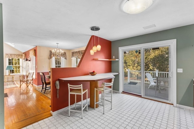 dining area featuring baseboards, lofted ceiling, a healthy amount of sunlight, and a chandelier