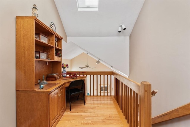 office space with lofted ceiling, light wood-style floors, and built in desk