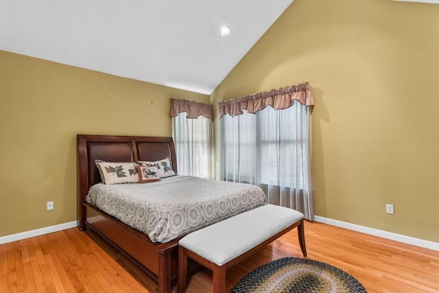 bedroom with baseboards, light wood-style floors, and high vaulted ceiling