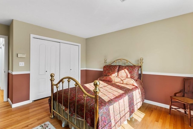 bedroom with a closet, baseboards, and wood finished floors