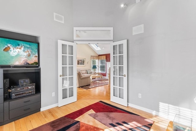 interior space featuring french doors, visible vents, wood finished floors, and vaulted ceiling