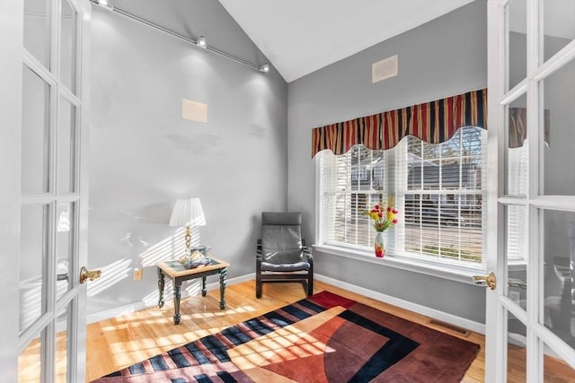 sitting room featuring lofted ceiling, wood finished floors, visible vents, and baseboards