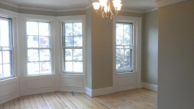 entryway featuring a chandelier, ornamental molding, a wealth of natural light, and wood-type flooring