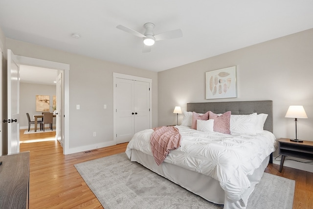 bedroom with ceiling fan, wood-type flooring, and a closet