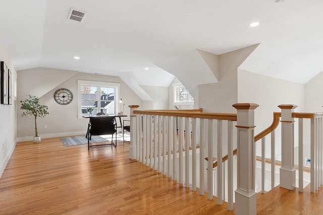 corridor featuring lofted ceiling and light hardwood / wood-style floors