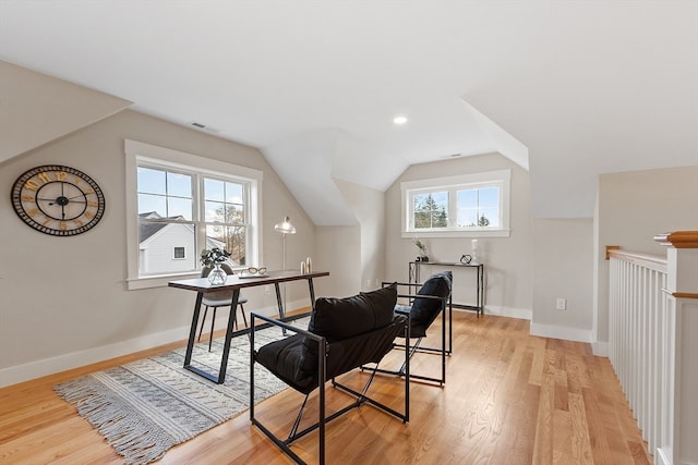 office space featuring light wood-type flooring, lofted ceiling, and plenty of natural light