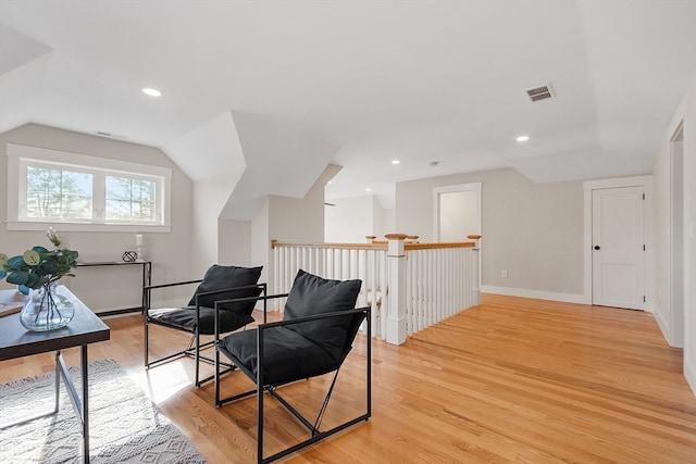 sitting room with light wood-type flooring and lofted ceiling