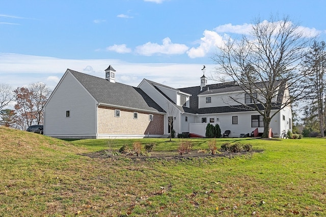 rear view of house featuring a lawn