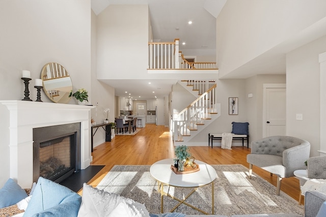 living room featuring light hardwood / wood-style floors and a towering ceiling