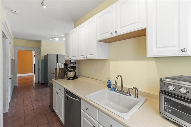 kitchen featuring white cabinets, rail lighting, a sink, and dishwasher
