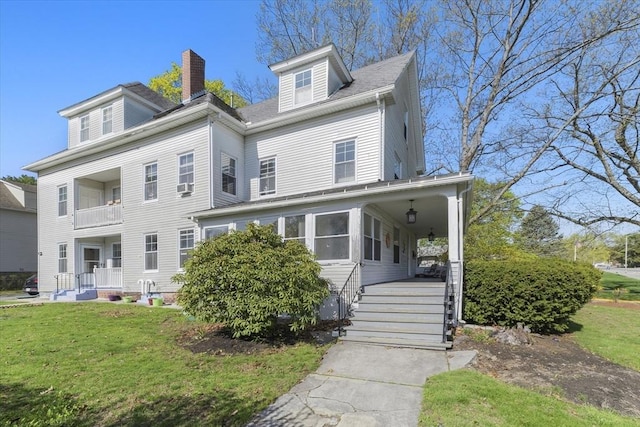 view of front facade featuring a porch, a front lawn, and a chimney