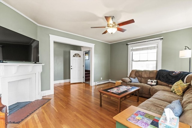 living area featuring crown molding, ceiling fan, wood finished floors, and a baseboard radiator