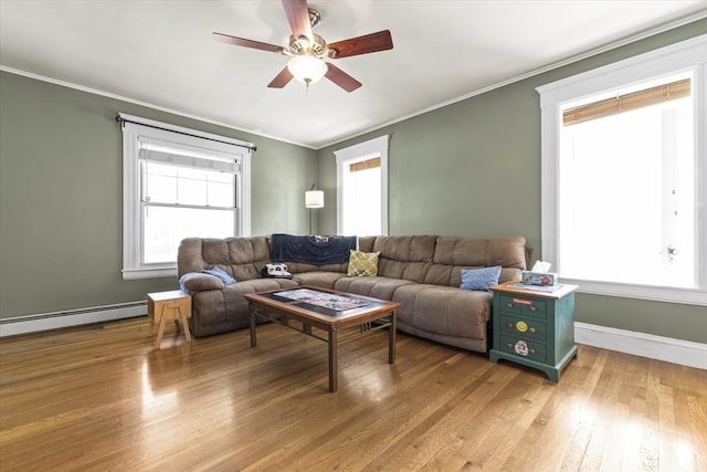 living area with a ceiling fan, crown molding, baseboards, a baseboard radiator, and light wood-style flooring