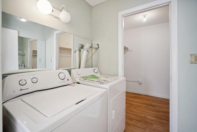 washroom with hardwood / wood-style flooring and washing machine and dryer