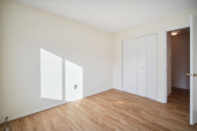 unfurnished bedroom featuring wood-type flooring and a closet