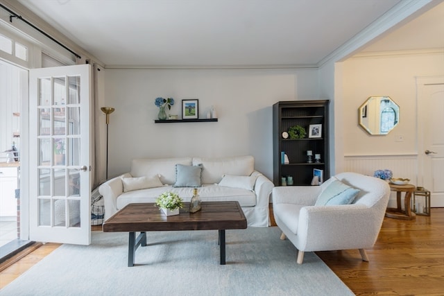 living room featuring crown molding, wood-type flooring, and plenty of natural light