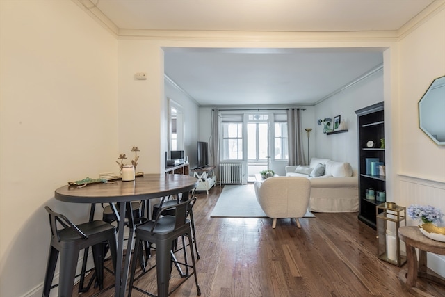 dining room featuring crown molding, radiator heating unit, and dark hardwood / wood-style flooring