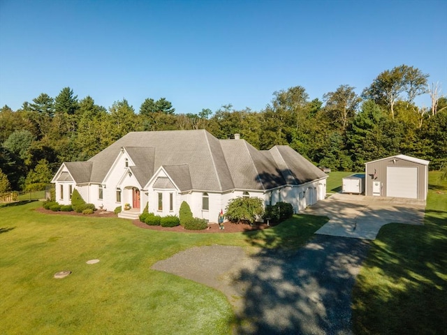 cape cod-style house featuring an outbuilding, a garage, and a front lawn