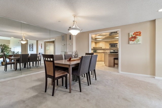 carpeted dining room featuring a textured ceiling