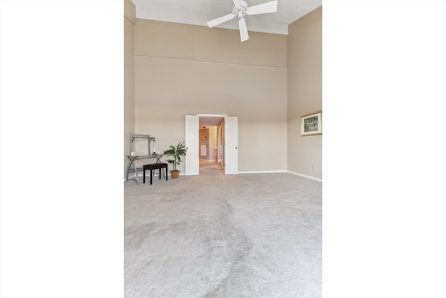 interior space with ceiling fan and a high ceiling