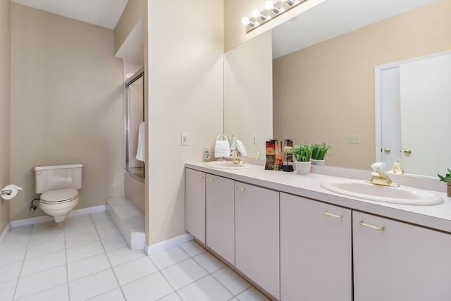 full bathroom with dual sinks, oversized vanity, toilet, combined bath / shower with glass door, and tile floors