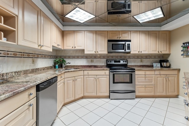 kitchen featuring light tile flooring, stainless steel appliances, tasteful backsplash, and light stone counters