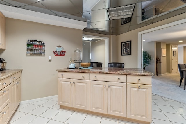 kitchen featuring light colored carpet and light stone counters