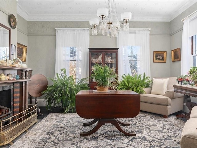 sitting room with ornamental molding, a notable chandelier, and a brick fireplace