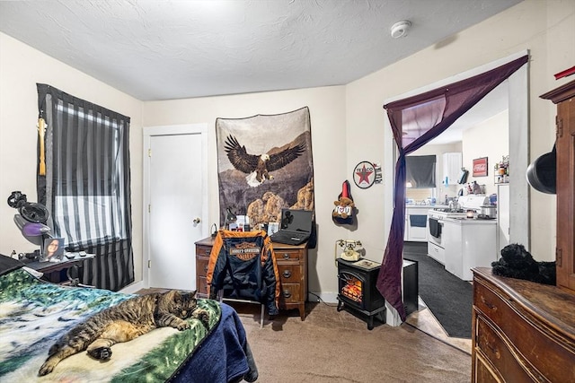 bedroom featuring a textured ceiling, carpet flooring, and a wood stove