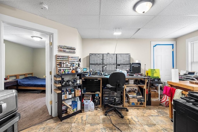 home office with a paneled ceiling and stone finish flooring